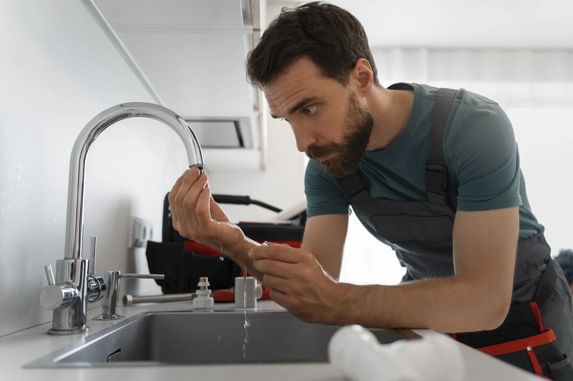 Fontanero profesional reparando grifo de cocina en Gijón