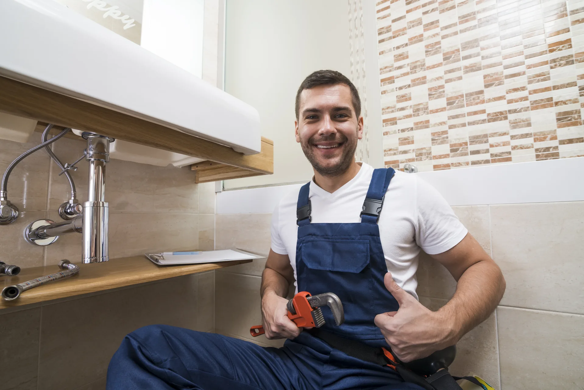 Técnico fontanero satisfecho tras completar desatasco profesional en Gijón